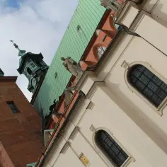 Dwie wieże katedry w Gnieźnie, z zielonym dachem i rzeźbą anioła. Poznaj gniezno ciekawostki!