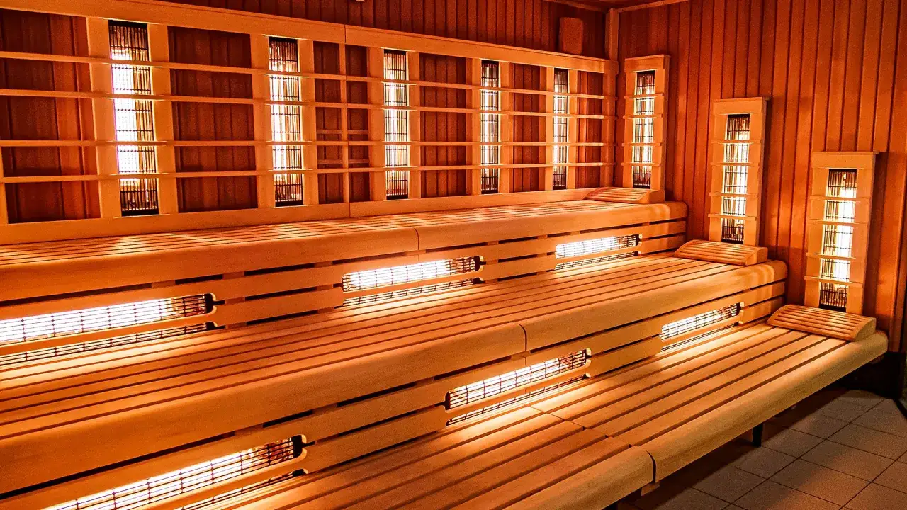 Drewniana sauna z wielopoziomowymi ławami i grzejnikami na podczerwień. Sprawdź termy maltanskie cennik i zrelaksuj się.