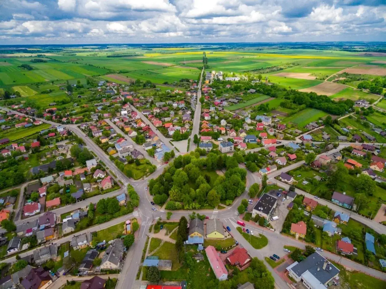 Widok z lotu ptaka na Krynki, malowniczą miejscowość z kolorowymi domami i zielonymi polami. Odkryj krynki atrakcje!