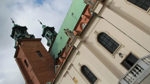Dwie wieże katedry w Gnieźnie, z zielonym dachem i rzeźbą anioła. Poznaj gniezno ciekawostki!